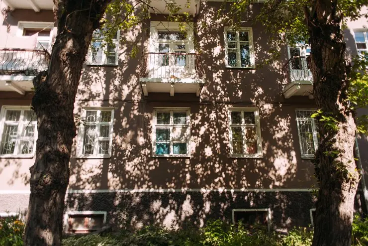 Фасад дома в узоре из теней старых деревьев